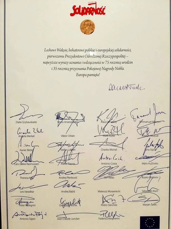 Laurka z logo „Solidarności” i medalem Nobla dla Lecha Wałęsy z okazji 75. urodzin, podpisana przez Donalda Tuska i przywódców państw Unii Europejskiej