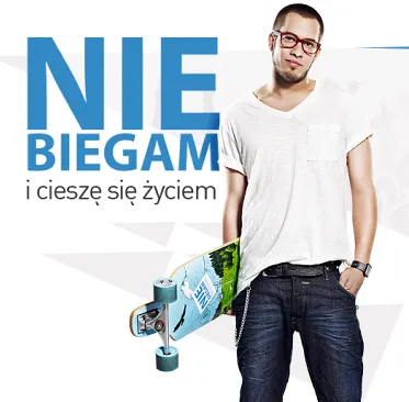 Plakat z napisem „Nie biegam i cieszę się życiem”, obok uśmiechnięty mężczyzna w okularach i białym T-shircie z deskorolką w ręku