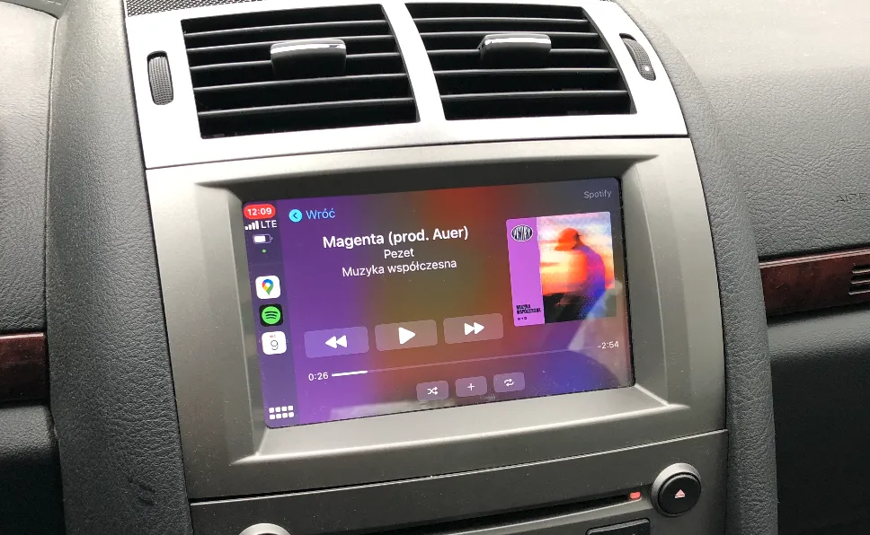Ekran Apple CarPlay w desce rozdzielczej Peugeota 407, odtwarzacz Spotify z utworem „Magenta” Pezeta